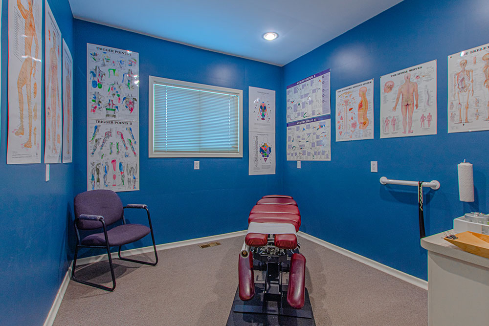 Room with Chiropractic table and posters.